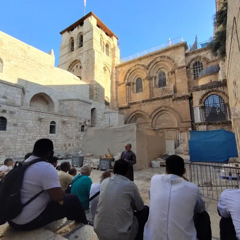 Participants in a formation programme seated in the courtyard of the Church of the Holy Sepulchre